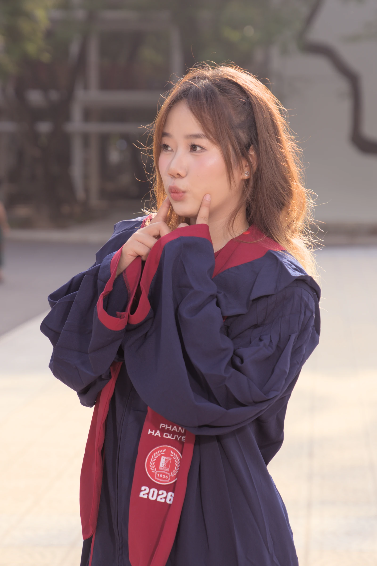 Quyên in her graduation gown, with warm sunlight in her hair